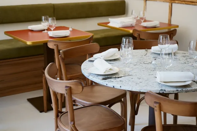 Dining room with green banquettes and terrazzo tables
